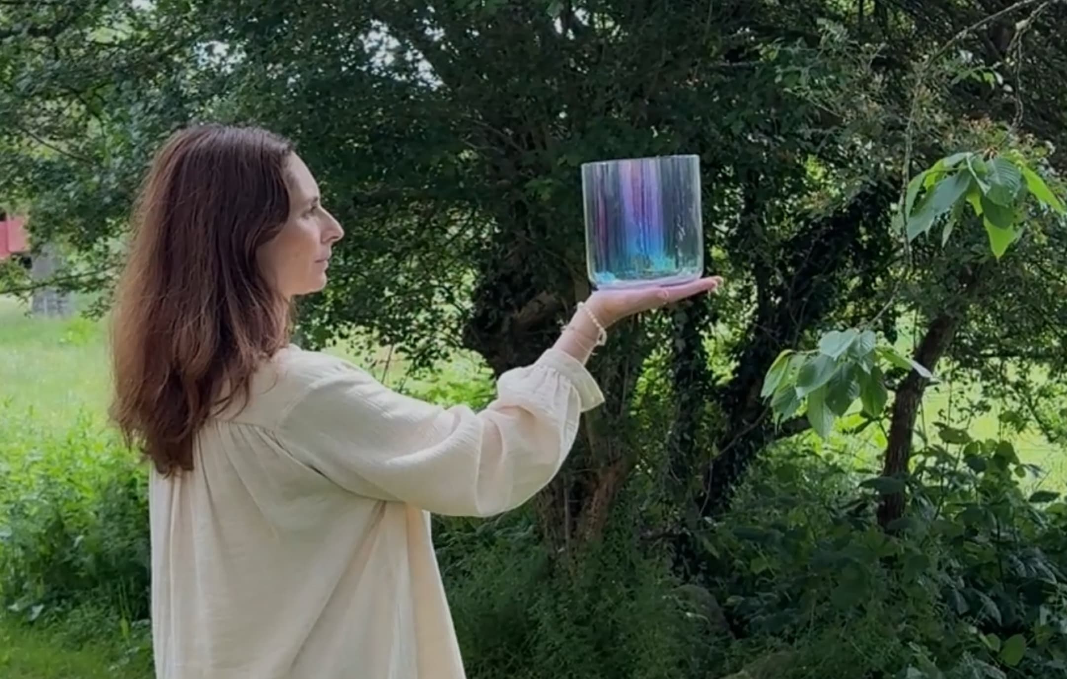Woman holding a crystal bowl in the forest
